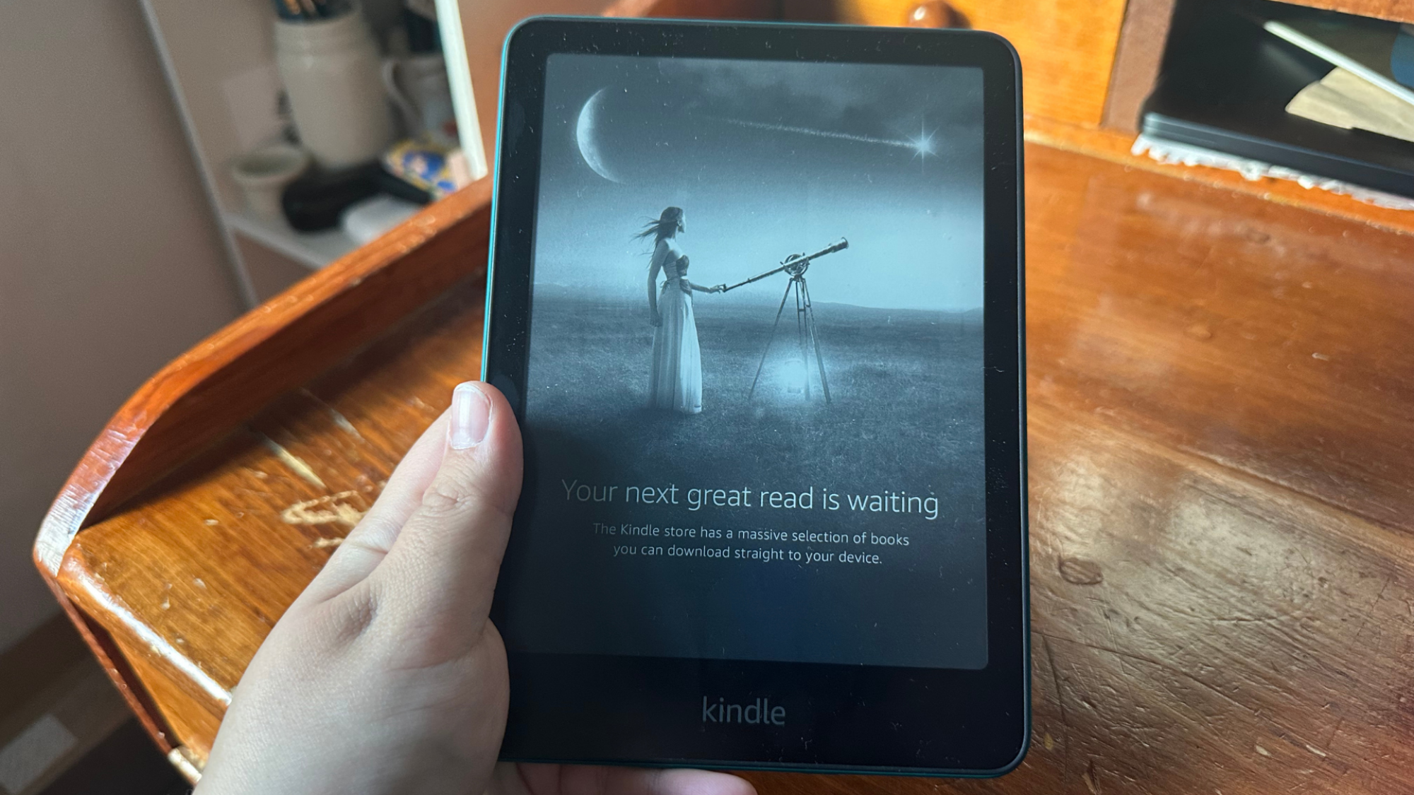 A person holding a Kindle Paperwhite.